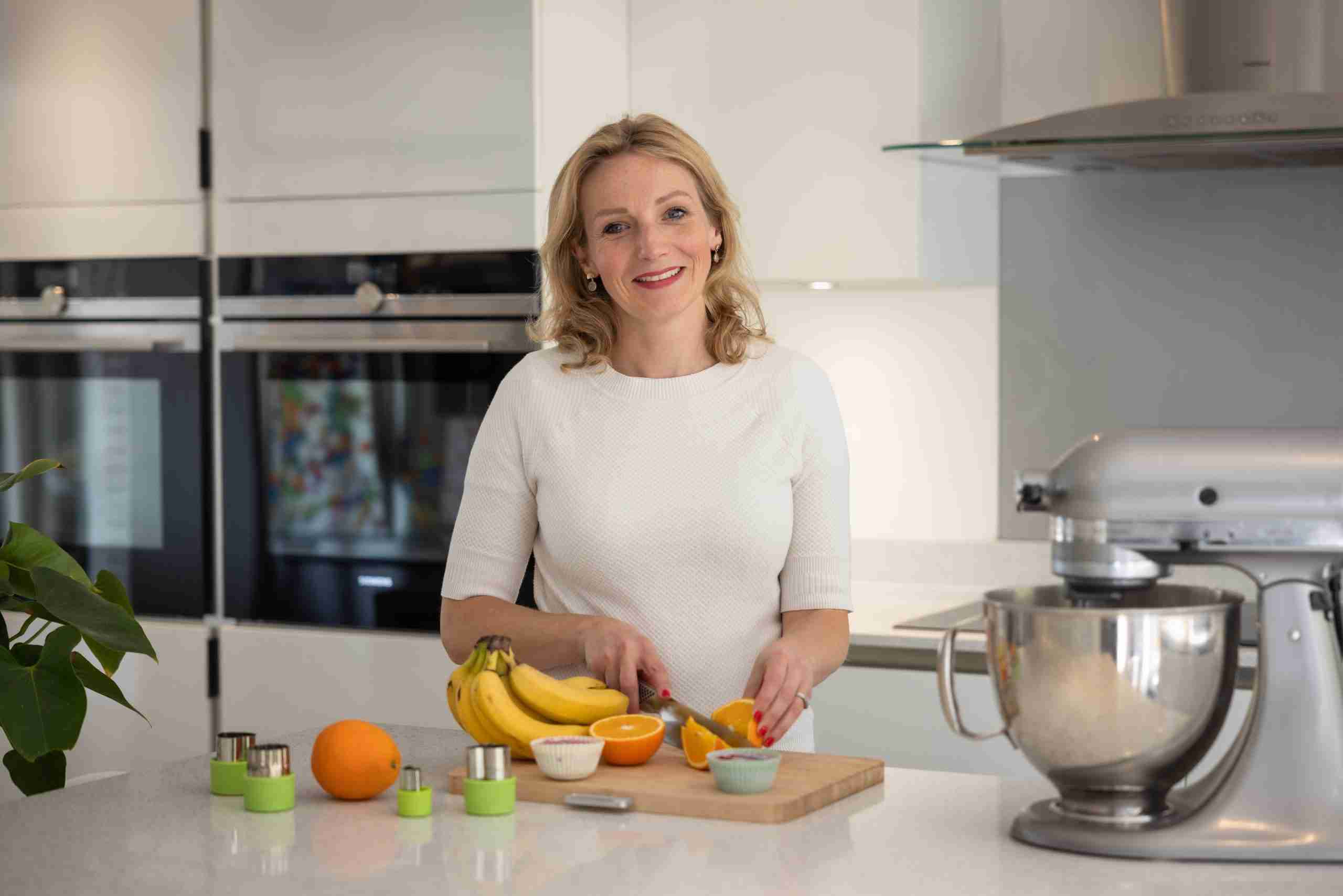 Dietitian in kitchen cutting fruit