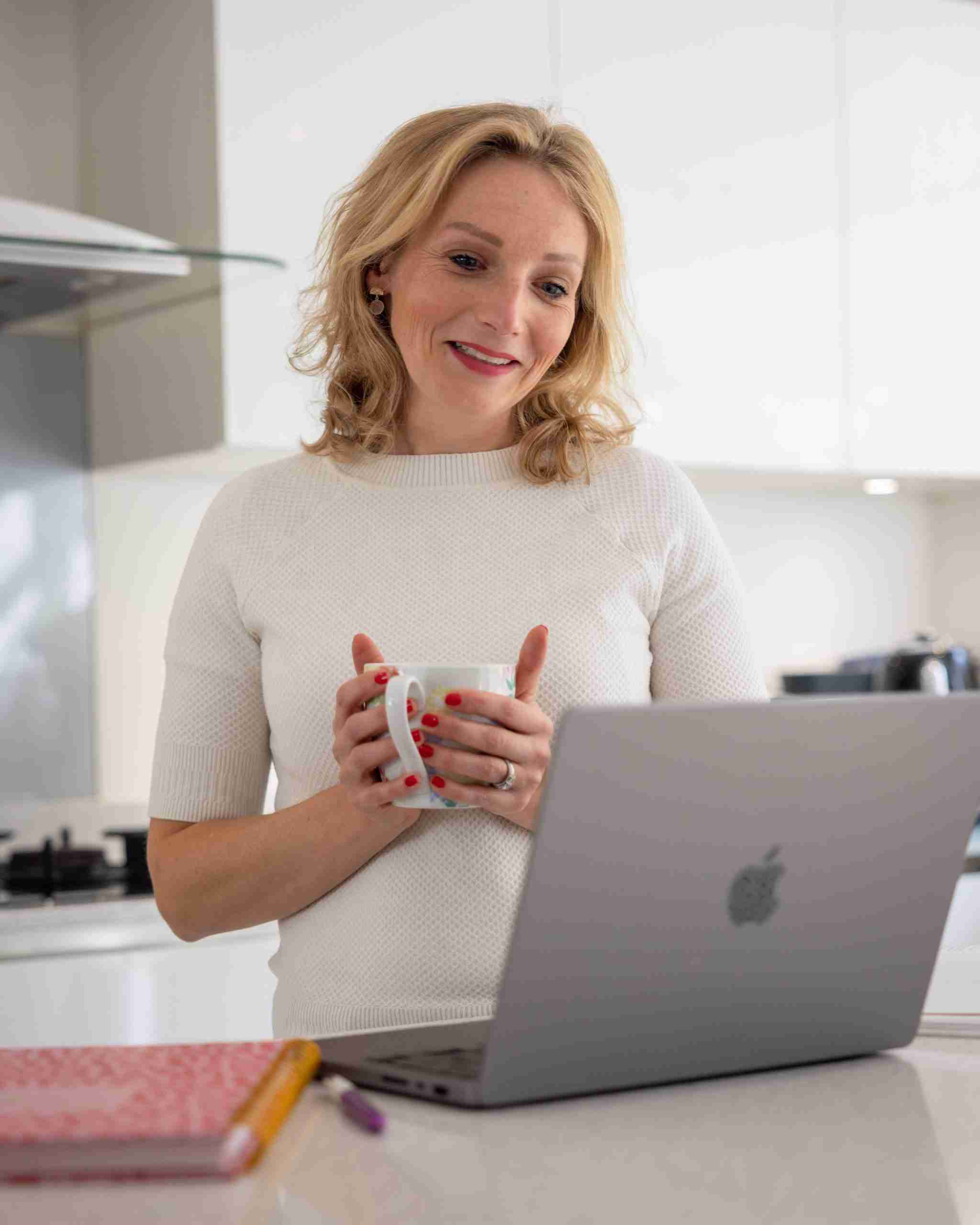 Emma Dietitian in the kitchen with a mug and computer