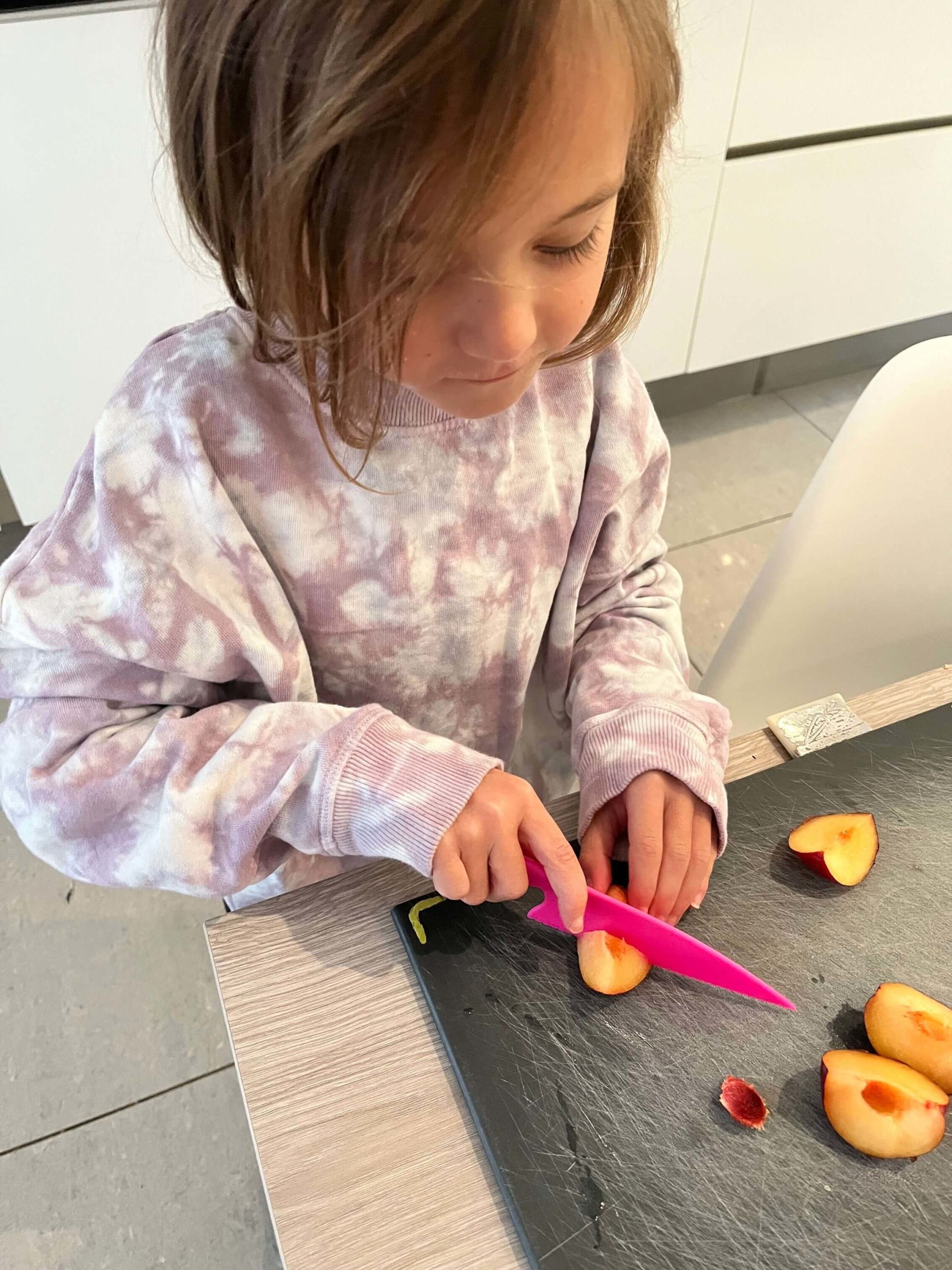 In kitchen cutting up fruit 